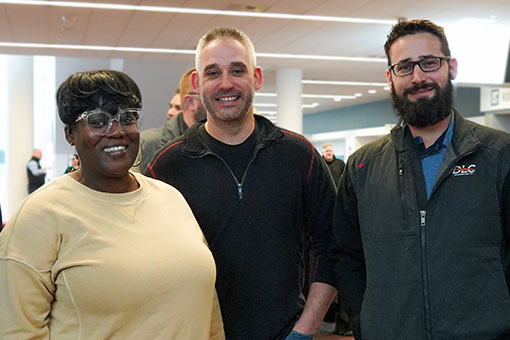 three smiling employees standing