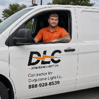 contractor in an orange polo sitting in white truck with a DLC logo